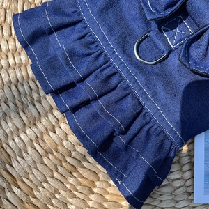 Detail of dark blue denim pet dress with double ruffles and silver metal D-ring attachment