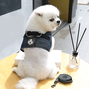 Dettaglio dell'imbracatura in denim per cani con logo SHINE su un cane bianco