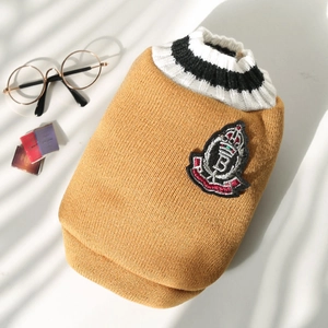 Detail of a yellow pet sweater with a high-neck collar and an embroidered crest badge