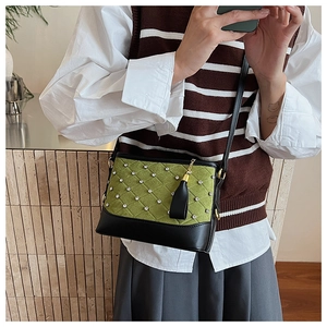 Detail of green quilted crossbody bag with sparkling crystals and black tassel