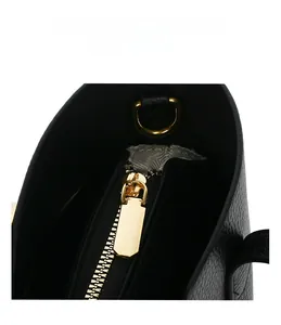 Dettaglio della cerniera dorata su una borsa tote in pelle nera con trama a litchi