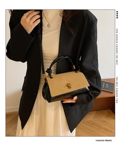 Detail of suede patchwork handbag with gold clasp, held by a model in a modern room