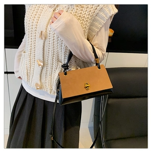 Side view of woman wearing a vintage suede patchwork crossbody bag with gold clasp