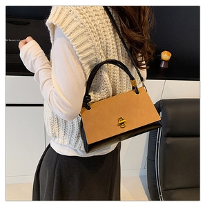 Detail view of the vintage suede patchwork handbag with a golden metallic twist lock