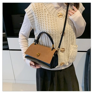 Detail of vintage suede patchwork crossbody bag with elegant golden twist lock and top handle