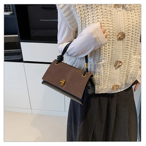 Detail of vintage suede patchwork handbag with gold clasp and knotted handle