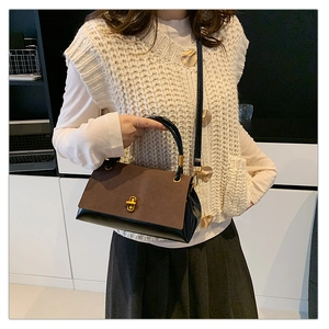 Detail of vintage suede patchwork crossbody bag with golden hardware and textured finish