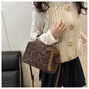 Gros plan du sac Boston léopard en daim avec rivets vintage et bandoulière réglable
