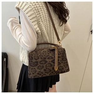 Détail du sac Boston imprimé léopard avec rivets dorés et poignées en cuir marron
