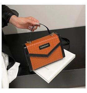 Detail of woven texture and contrast color design on a chic messenger bag