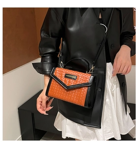 Detail of orange woven crossbody bag with black leather trim and Fashion Bag label