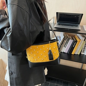 Chic yellow quilted hobo bag with rhinestone accents and black leather fringe charm