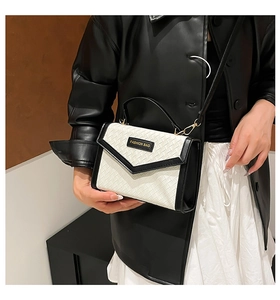 Close-up of contrast weave crossbody bag with fashion tag and metal buckle detail