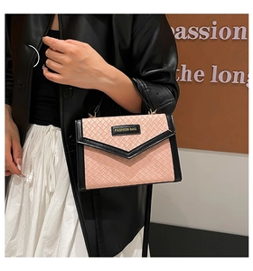 Detail of pink woven texture and black leather flap on a stylish crossbody handbag