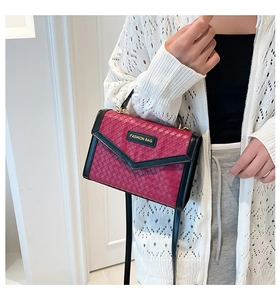 Detail of red intrecciato woven crossbody bag with gold metal fashion hardware
