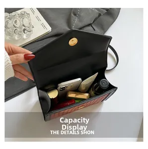 Detail view of woven leather shoulder bag showing inner capacity with daily essentials