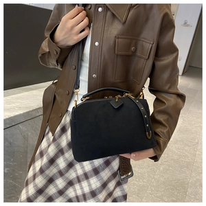 Détails du sac oreiller en daim noir avec boucles dorées et rivets sur les côtés