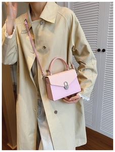 Pink snake-texture leather handbag shown as a crossbody bag with a beige trench coat