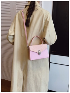 Detail of pink snake pattern patchwork and silver oval rotating lock on crossbody box bag