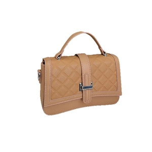 Light brown quilted leather crossbody bag with silver buckle and top handle in a minimalist style