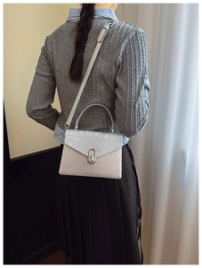 Fashionable grey snakeskin patchwork crossbody bag worn by a model to show size and fit