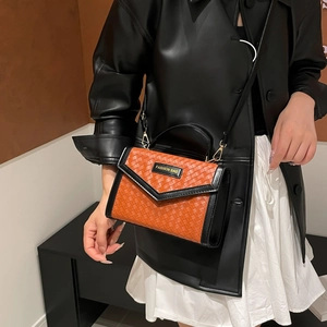 Orange woven leather crossbody bag with black trim and fashion branding on front