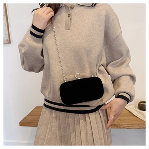 Détail de la pochette de soirée en velours noir avec fermoir en strass et chaîne fine
