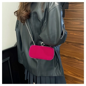 Détail de la pochette de soirée en velours fuchsia avec chaîne argentée et fermoir strass