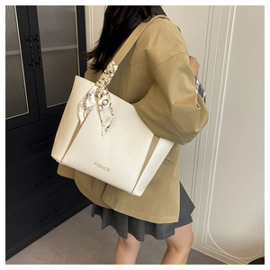 Détail d'un sac cabas bicolore en cuir grainé avec un foulard en soie sur la bandoulière