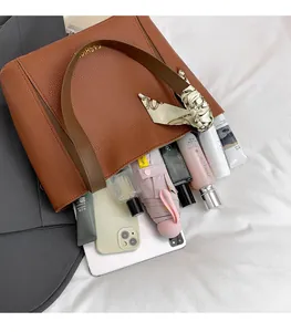 Dettaglio dell'interno della borsa tote in pelle marrone con manico avvolto in seta