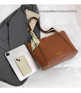 Vista dall'alto borsa tote marrone con foulard e confronto dimensioni con un iPad