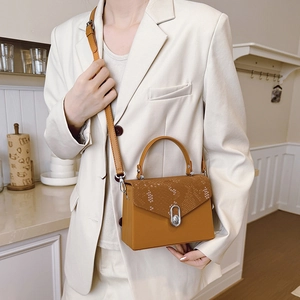 Elegant mustard yellow square box bag with snake pattern flap and silver twist lock detail