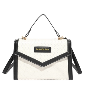 Contrast woven handbag in black and white with gold hardware and fashion tag detail