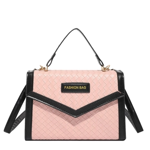Sac à main rose tressé avec bordure noire et rabat en V sur fond blanc épuré