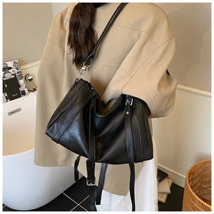 Mannequin portant un grand sac cabas en cuir ciré noir avec détails plissés