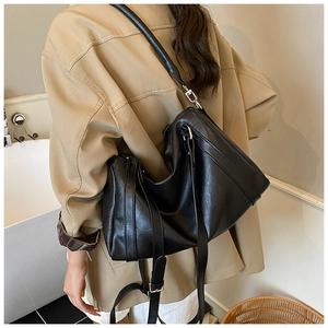 Détail du sac cabas en simili cuir noir avec texture plissée et boucles métalliques