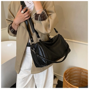 Détail d'un sac cabas en cuir ciré mat avec texture plissée et ferrures argentées