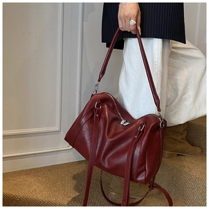 Détail de la texture en cuir ciré rouge foncé et fermeture éclair argentée