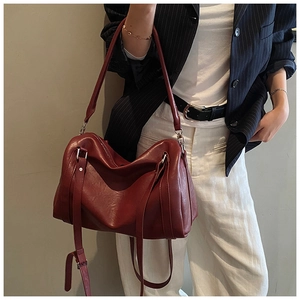 Détail du sac cabas en cuir ciré bordeaux avec texture plissée porté par un mannequin chic