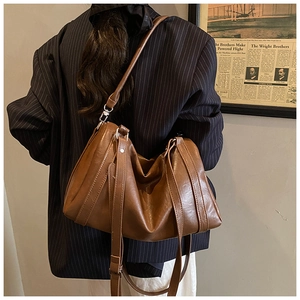 Détail d'un sac à bandoulière vintage en cuir huilé marron avec rivets métalliques