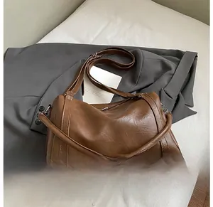 Détail de la texture en cuir ciré de haute qualité sur un sac boston vintage marron