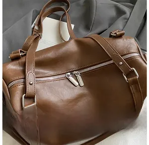 Vue macro du sac en cuir marron avec doubles fermetures éclair argentées et rivets en métal