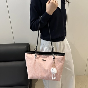 Pink textured tote bag with black leather straps and plush charm for women
