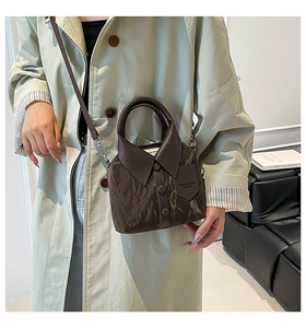Detailed side view of brown pleated crossbody bag with shirt collar design and leather strap