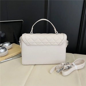 Detailed view of cream quilted crossbody bag with silver buckle and detachable shoulder strap
