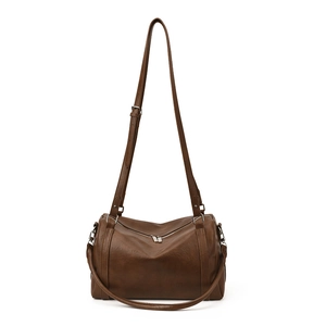 Sac Boston en cuir ciré marron foncé avec détails argentés sur fond blanc neutre