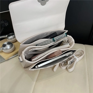 Detail view of the multi-compartment interior and spacious structure of the crossbody bag