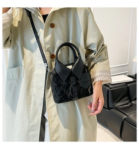 Détail d'un sac à main noir avec design de col de chemise unique et boucles métalliques