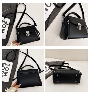 Detail view of black lychee leather handbag showing silver lock, base studs and strap