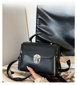 Close-up of black lychee grain leather handbag featuring a silver twist lock and handle